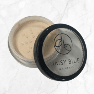 An open container of Birch Foundation powder with a sifter, labeled “Daisy Blue Naturals,” is shown on a white marble background.