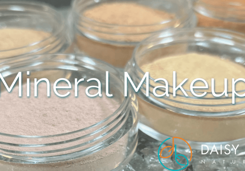 Small clear jars of loose mineral makeup powders in various shades, showcasing the benefits of mineral makeup, with “Mineral Makeup” overlaid and the Daisy Blue Naturals logo in the lower right corner.
