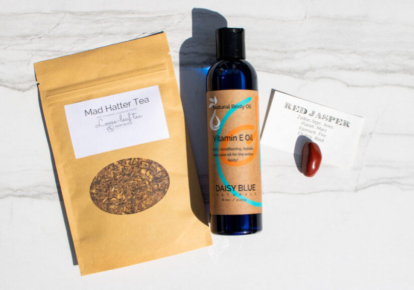 Daisy Blue April Trio, featuring the Mad Hatter Tea, Vitamin E Body Oil and Red Jasper Stone